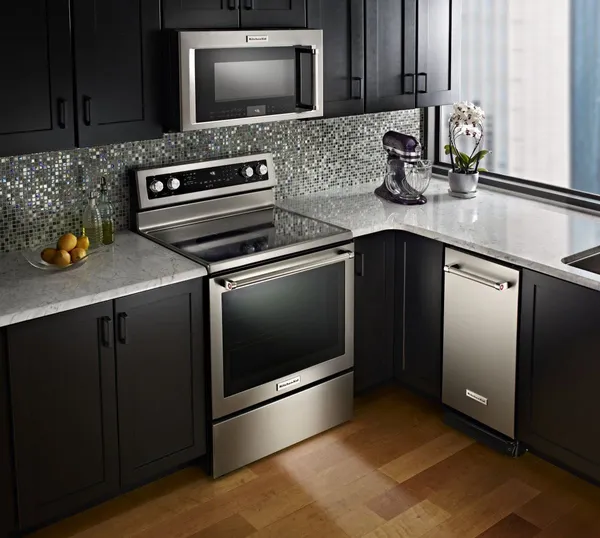 Stainless steel KitchenAid appliances in kitchen with dark brown cabinets